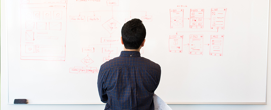 Man staring at whiteboard thinking