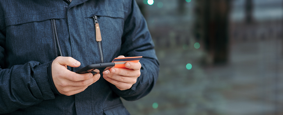 Hands holding phone and bank card