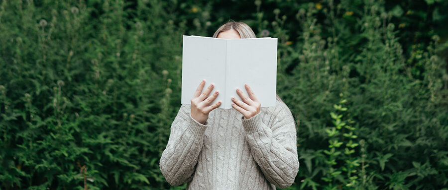 Woman reading book in a field